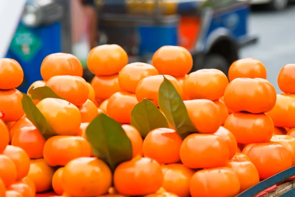 Oranžové plody zelené listy v trhu — Stock fotografie