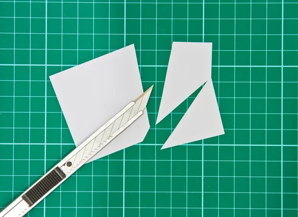 Schneidmesser schneidet weißes Papier auf Schnittmatte — Stockfoto