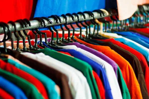 Colores del arco iris. Variedad de camisas casuales en perchas — Foto de Stock