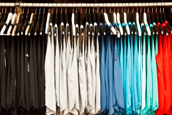 Kleuren van de regenboog. verscheidenheid van casual shirts op hangers Stockafbeelding