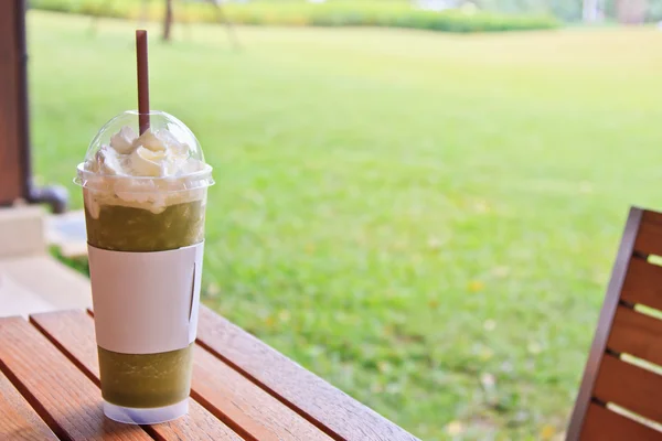 Groene thee op de houten tuinmeubelen — Stockfoto