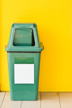 Sarı backgrond ile yeşil plastik atık konteyner