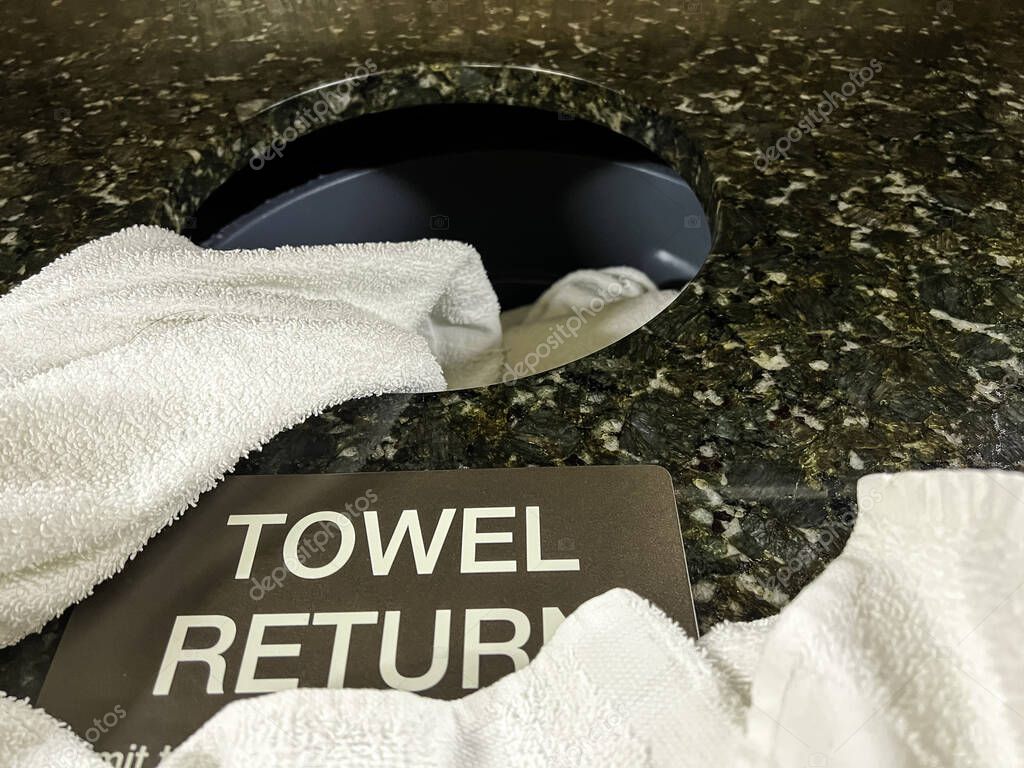 A used white towel on a granite towel return.