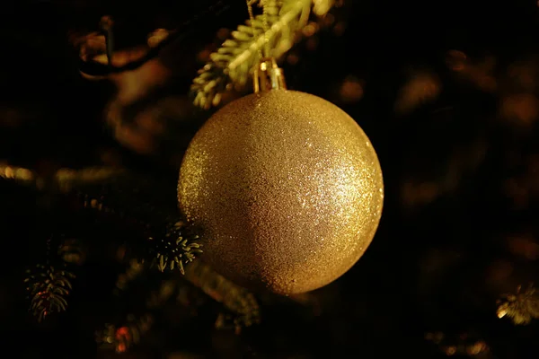一只黄色的球挂在圣诞树上 — 图库照片
