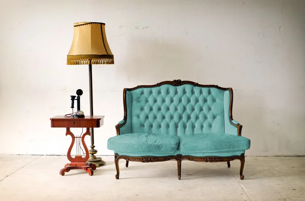 Ancient leather sofa and telephone in white room — Stock Photo, Image