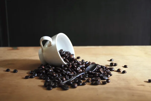 Kahve çekirdekleri ve fincan kahve arka plan — Stockfoto