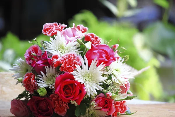 Mooi boeket van roze roze bloemen, op tabel met een groene achtergrond — Stockfoto