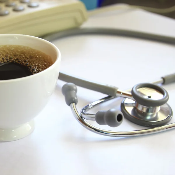 Estetoscópio e uma xícara de café — Fotografia de Stock