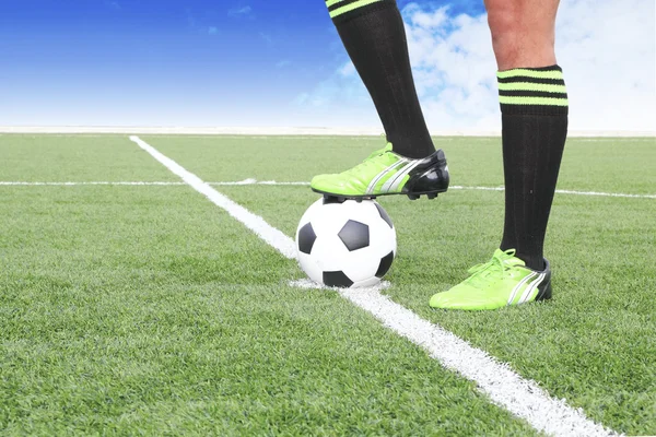 Pelota de fútbol con pie de jugador pateándola — Foto de Stock