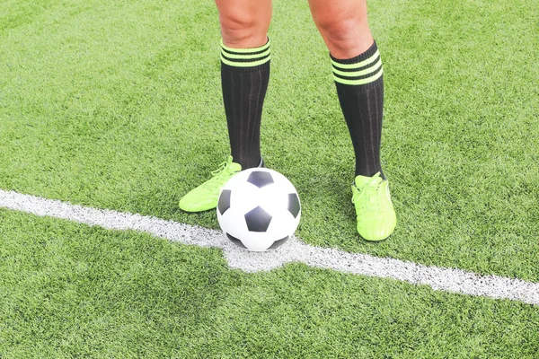 Fußball mit dem Fuß des Spielers, der ihn tritt — Stockfoto