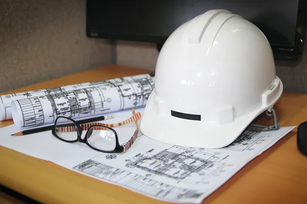 File of safety helmet and architect plant on wood table — Stock Photo, Image