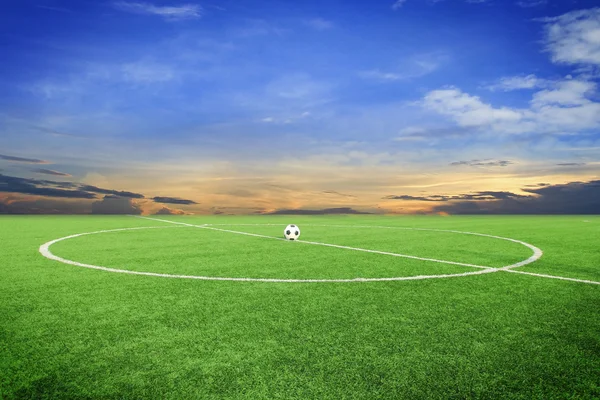 Balón de fútbol en el campo de fútbol con puesta de sol —  Fotos de Stock