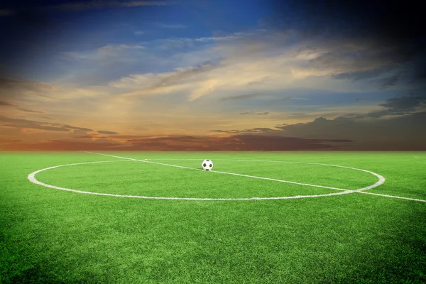 Soccer ball on soccer field with sun set — Stock Photo, Image