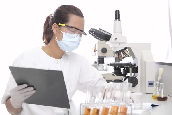 Jovem pesquisadora segurando papert em laboratório médico — Fotografia de Stock