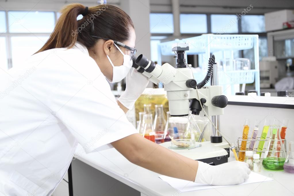 Female Scientists Using Microscopes In Laboratory