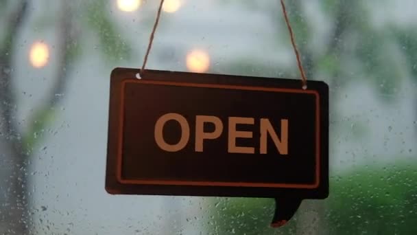 雨の背景を持つコーヒーカフェ店のドアにオープンサインを歓迎 — ストック動画