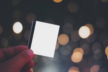 Bokeh Light arka planında erkek eli boş kağıtlar (biletler, el ilanları, davetiyeler, kuponlar)