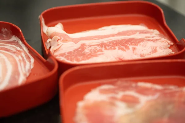 Kırmızı Tepside Servis Edilen Ince Dilimlenmiş Çiğ Domuz Eti Seçici — Stok fotoğraf