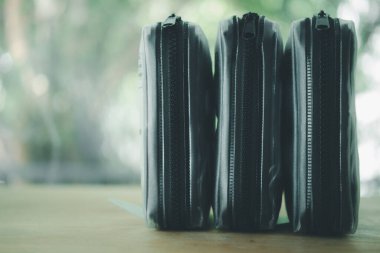 Tahta masaya yerleştirilmiş, fermuarlı, şeffaf üç çanta.