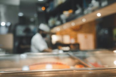 Japon usulü ve suşi barında maske takan bir şefin bulanık arka planı.