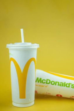 Samut Prakan, Tayland - 24 Ekim 2021: McDonald 's restoranından gelen plastik bardak buzlu içecek sarı arka planda