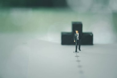 Minyatür bir iş adamı hedefe doğru yürür. Girişim iş konsepti