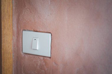 Çimento arka planındaki ışık düğmesi, minimalizm.