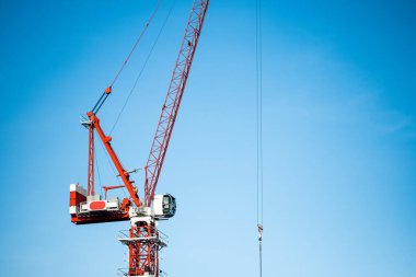 Mavi gökyüzüne karşı kırmızı vinç kulesi. İnşaat alanı