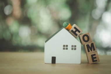 Ev yapımı ahşap metin küpleri ve alfabeye yerleştirilmiş minyatür kaktüslü beyaz ahşap ev. İyi bir ortamda ev kavramı