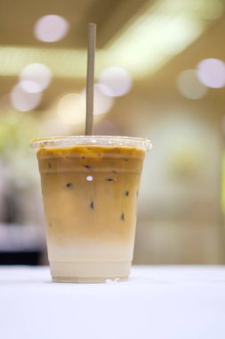 Toplantı odasındaki masada plastik bardakta buzlu kahve lattesi.