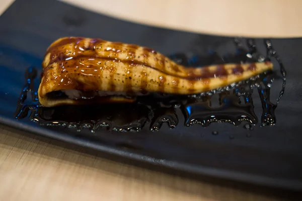 烤海鳗鱼寿司配甜酱汁在黑盘上 — 图库照片