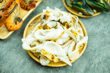 Etrafında bir sürü deniz ürünü olan leziz bir kalamar dilimi.