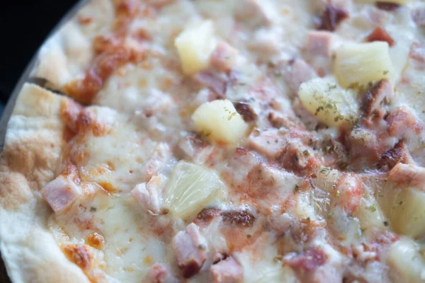 Delicious thin ham and pineapple pizza with mozzarella cheese for a tasty finger snack