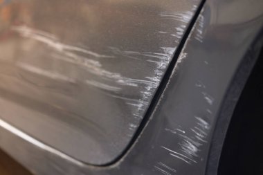 Arabanın kapısında küçük bir kazaya ait sıyrık var. Kapat.