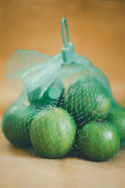 Yeşil Torbasında Taze Limon Yığını — Stok fotoğraf