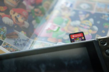 Bangkok, Tayland - 19 Aralık 2021: Mario Party Superstars video oyunu kartuşu bir Nintendo Anahtarı konsoluna yerleştiriliyor. 2021 'deki yeni versiyon.