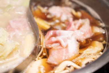 Shabu yapmak için tencerede çiğ domuz eti. Kapat.