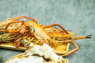 Tahta tepside leziz ızgara karidesin seçici odağı.