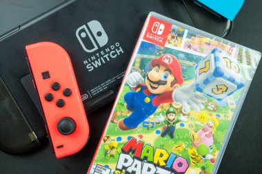 Bangkok, Tayland - 22 Aralık 2021: Yeni bir oyun kutusu Mario Party Superstars ve Joy-Con, Nintendo Switch denetleyicisi Nintendo Switch Logo 'nun yanına yerleştirildi.