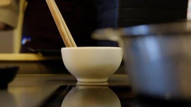 Garson, siyah tepside çiğ yemek servis ediyor. 