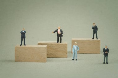 Çeşitli pozisyonlardaki yatırımcıların grup minyatür işadamı. Yatırım analizi ve seçim kavramı