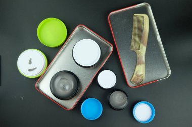 Saçını şekillendirmek için yuvarlak plastik kutuda gri krem. Erkek ürünleri reklamcılığı. Saç dökülmesine karşı tedavi ve bakım