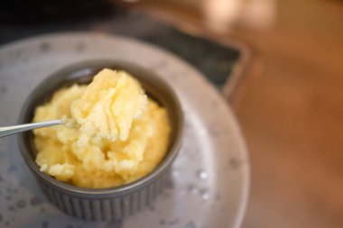 Delicious creamy mashed potatoes with butter on spoon. Close up