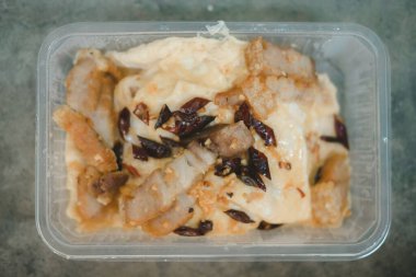 Stir-fried pork with salt garlic and pepper served on scrambled eggs put in box. Top view