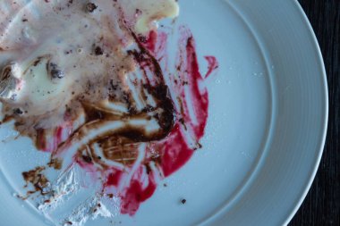 Dirty dishes of blueberry and chocolate sauce  stains in white dish after eating
