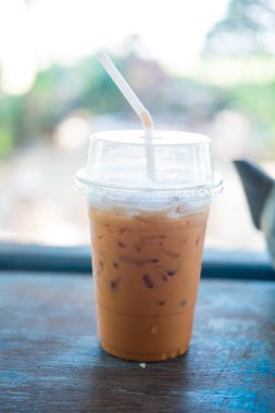 Iced thai milk tea is a traditional Thai drink that has long been popular placed on wood table
