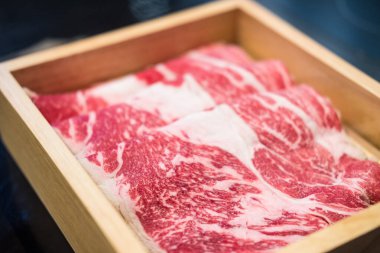 Japon wagyu bifteği, sukiyaki için ahşap kutuda dilimlenmiş.