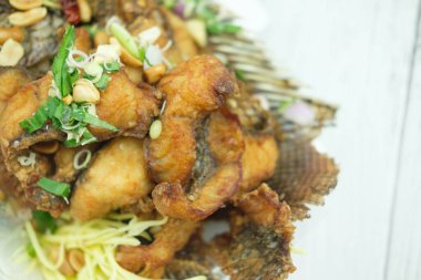 Kızarmış balık ve karışık bitki. Lezzetli Tayland yemeği. Kapat.