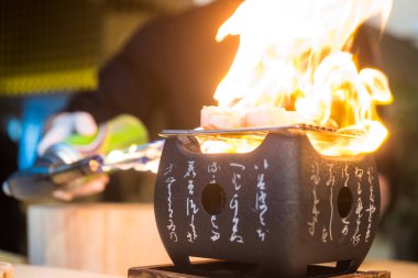 Şef ızgara deniz tarağı, ızgarada ızgara ve sıcak kömür sobası ile geleneksel Japon yemeği..