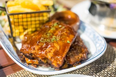 Fırında domuz pirzolası ve yanında patates kızartması.